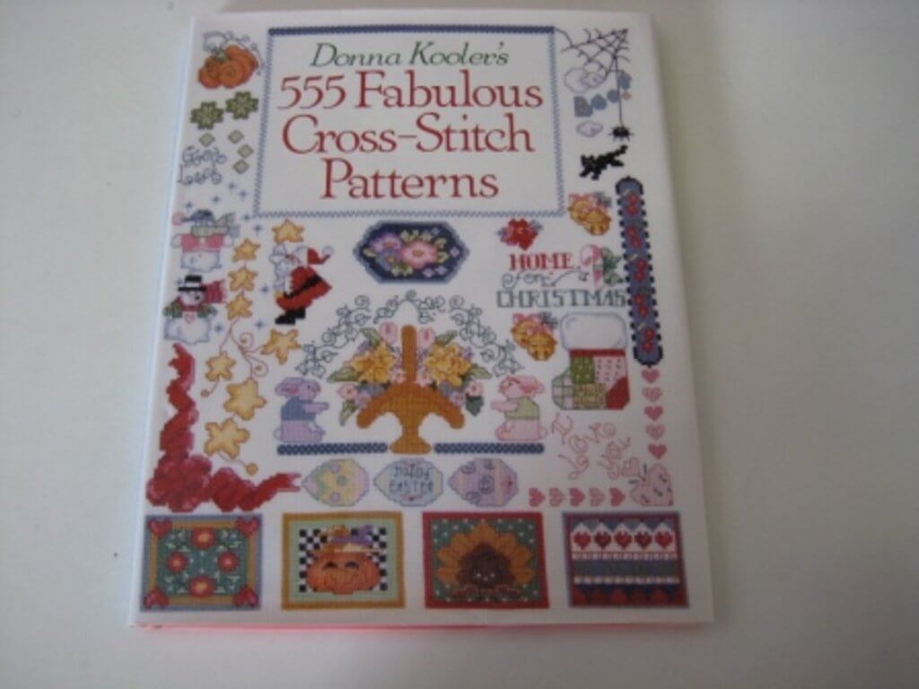 Cover of Donna Kooler's 555 Fabulous Cross-Stitch Patterns featuring vibrant designs and motifs.